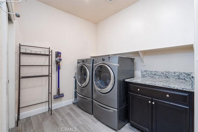 315 Timberline Way S, Madera, CA 93636 - washroom with washer and clothes dryer, baseboards, light wood-style flooring, and cabinet space