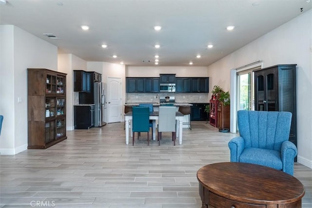 315 Timberline Way S, Madera, CA 93636 - kitchen with appliances with stainless steel finishes, light wood-type flooring, open floor plan, baseboards, and a breakfast bar