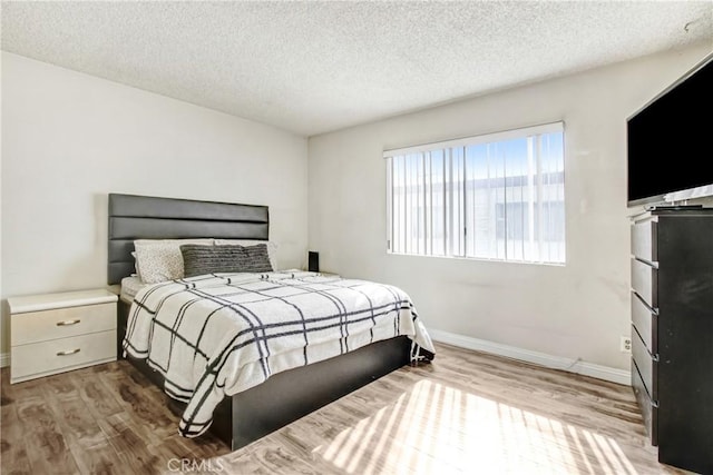 bedroom featuring hardwood / wood-style flooring and a textured ceiling