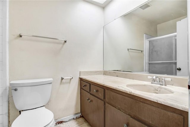 bathroom with toilet, vanity, tile patterned floors, and a shower with shower door