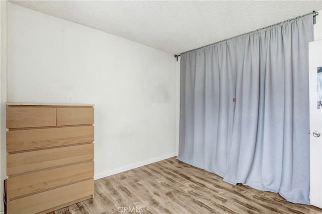 empty room with hardwood / wood-style flooring and a textured ceiling