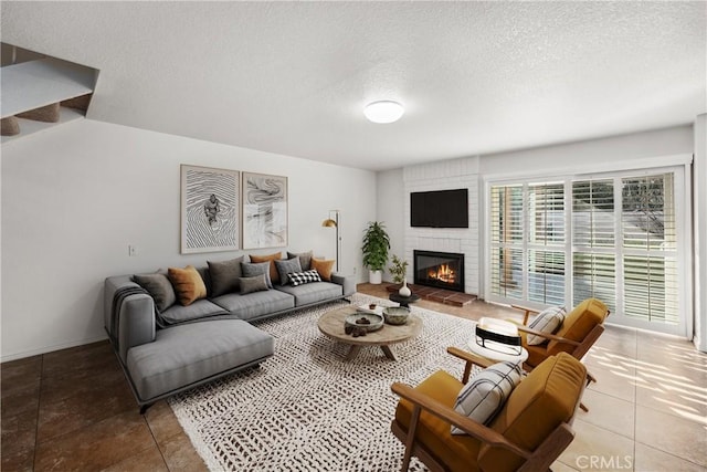 living room featuring tile patterned flooring, a fireplace, and a textured ceiling