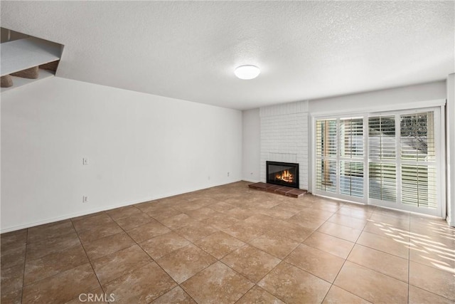 unfurnished living room featuring tile patterned floors, a fireplace, and a textured ceiling