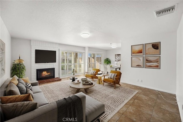 tiled living room with a textured ceiling and a fireplace