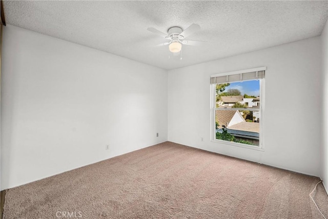 carpeted spare room featuring ceiling fan and a textured ceiling