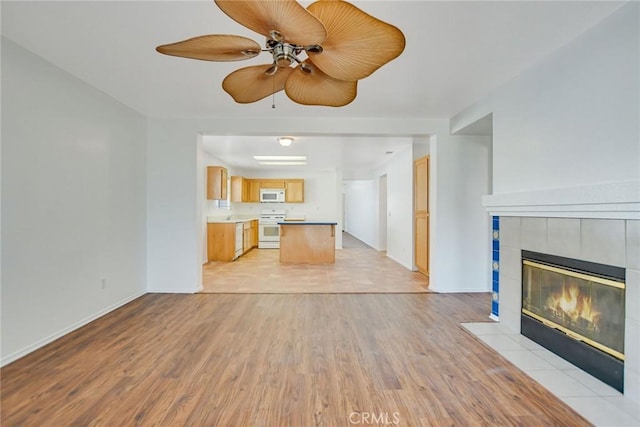 unfurnished living room with light hardwood / wood-style flooring, a fireplace, and ceiling fan