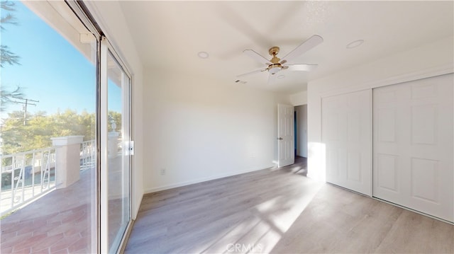 unfurnished bedroom featuring light wood-type flooring, a closet, ceiling fan, and access to outside