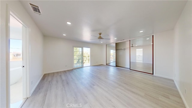 spare room with light wood-type flooring and ceiling fan