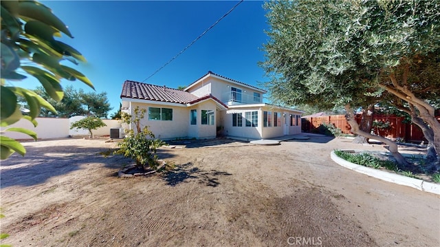 rear view of house with central AC unit and a patio