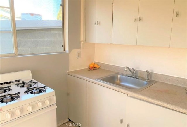 26302632 L St Unit A, B, C, Bakersfield, CA 93301 - kitchen with white range with gas cooktop, a sink, light countertops, and cream cabinetry