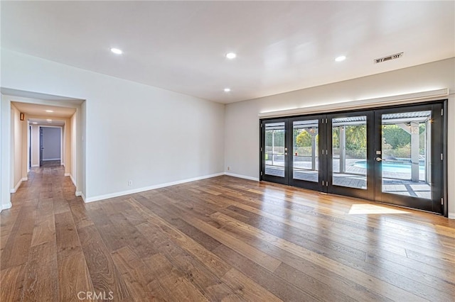 spare room with hardwood / wood-style floors and french doors