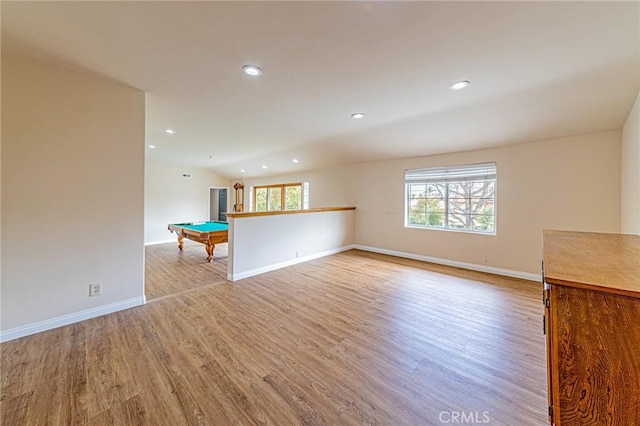 unfurnished living room featuring vaulted ceiling, pool table, and light hardwood / wood-style flooring