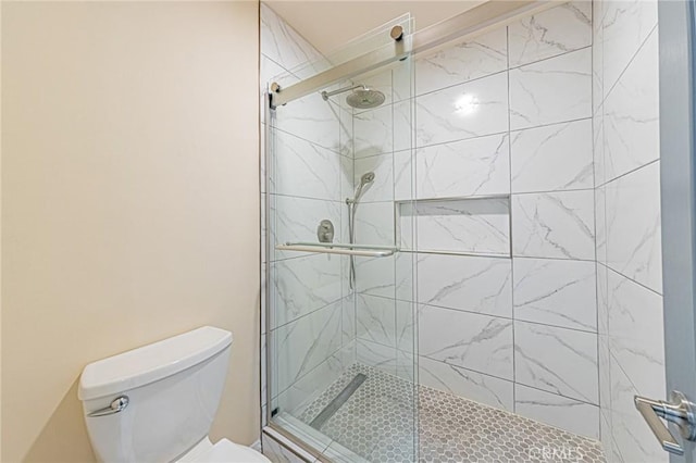 bathroom featuring toilet and an enclosed shower