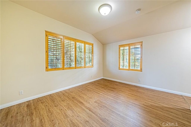 empty room with lofted ceiling and hardwood / wood-style floors