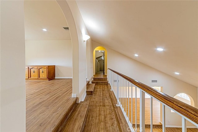 corridor featuring lofted ceiling and light hardwood / wood-style flooring