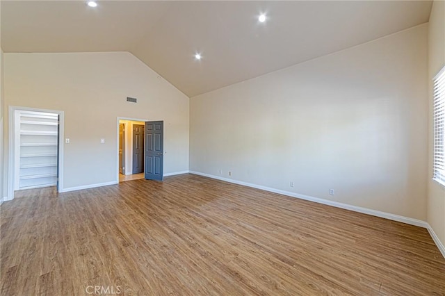 spare room featuring high vaulted ceiling and light hardwood / wood-style flooring