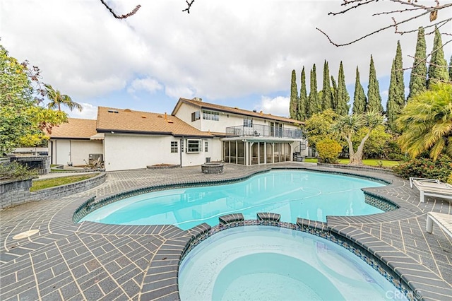 view of pool featuring an in ground hot tub and a fire pit