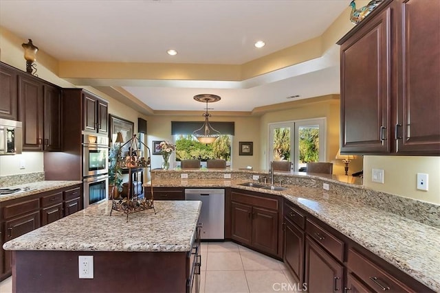 kitchen featuring a kitchen island, decorative light fixtures, sink, kitchen peninsula, and stainless steel appliances