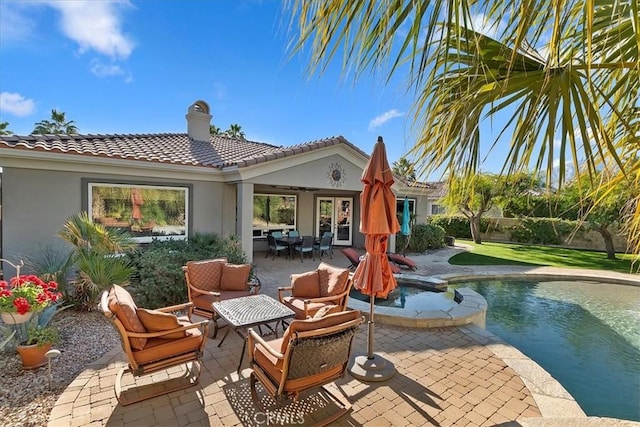 rear view of property with outdoor lounge area and a patio