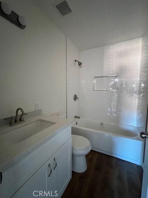 full bathroom featuring bathtub / shower combination, visible vents, toilet, vanity, and wood finished floors