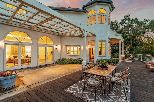 deck at dusk featuring a pergola