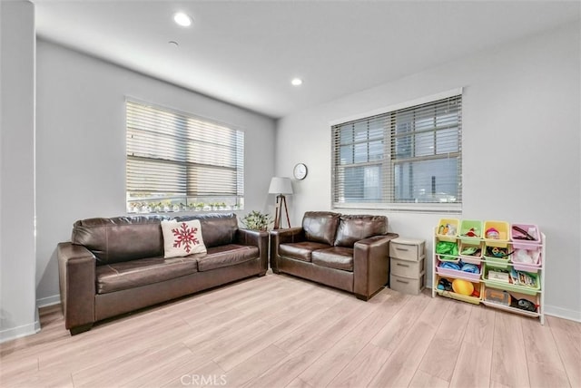 living room featuring recessed lighting, baseboards, and light wood finished floors