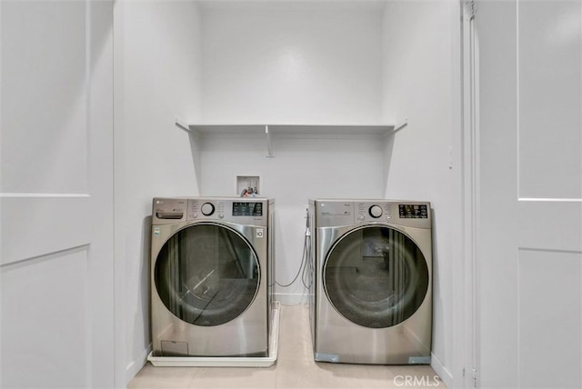 washroom featuring laundry area, light tile patterned floors, and separate washer and dryer