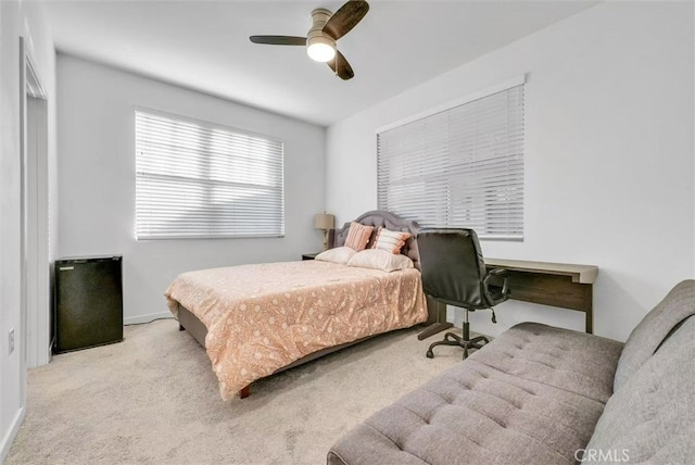 bedroom featuring a ceiling fan and light colored carpet