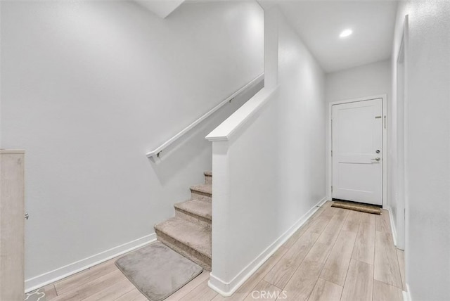 stairs featuring recessed lighting, wood finished floors, and baseboards