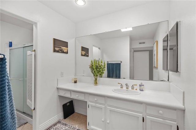 bathroom featuring tile patterned flooring, vanity, and a shower with shower door