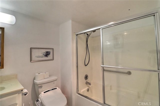 full bathroom with vanity, shower / bath combination with glass door, and toilet