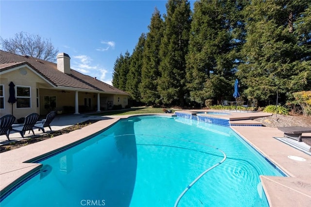 view of swimming pool featuring an in ground hot tub and a patio