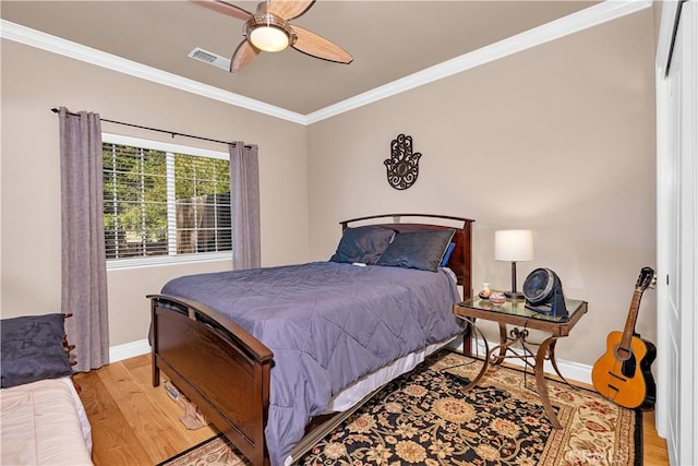 bedroom featuring ornamental molding, light hardwood / wood-style floors, and ceiling fan