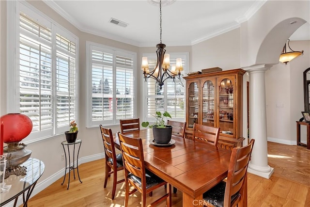 dining space with ornamental molding, decorative columns, and light hardwood / wood-style floors