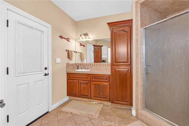 bathroom featuring vanity, tile patterned floors, backsplash, and a shower with shower door