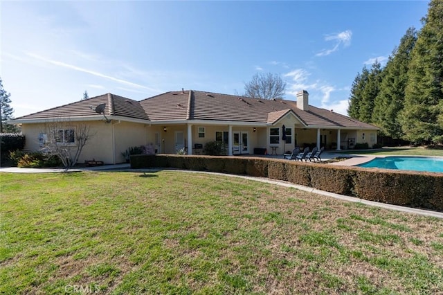 back of house with french doors, a yard, and a patio area