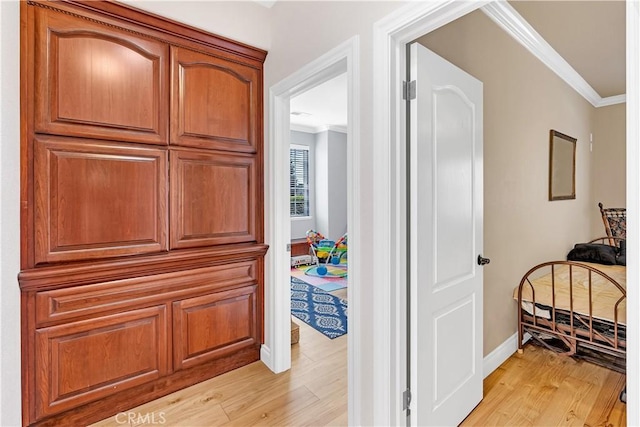 hall with crown molding and light hardwood / wood-style floors