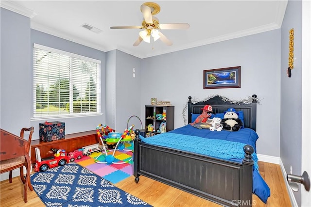 bedroom featuring hardwood / wood-style floors, ornamental molding, and ceiling fan