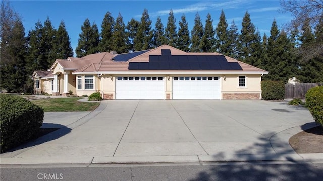 single story home featuring a garage and solar panels