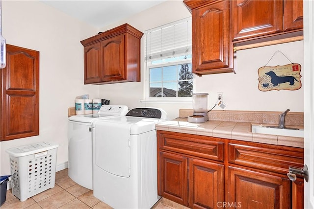 laundry room with washer and dryer, sink, cabinets, and light tile patterned flooring