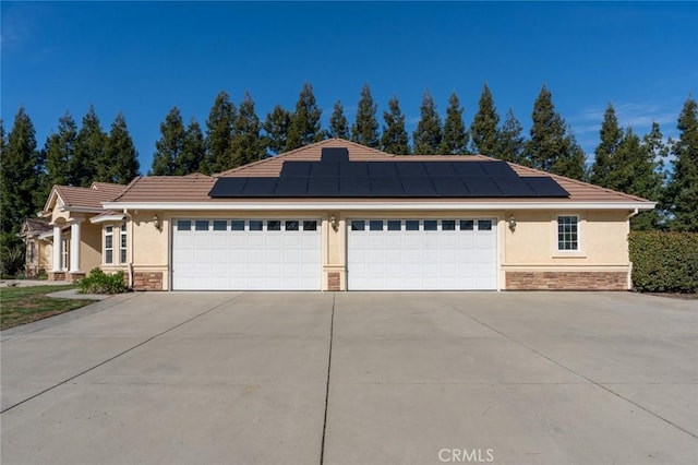 view of front of property featuring a garage and solar panels