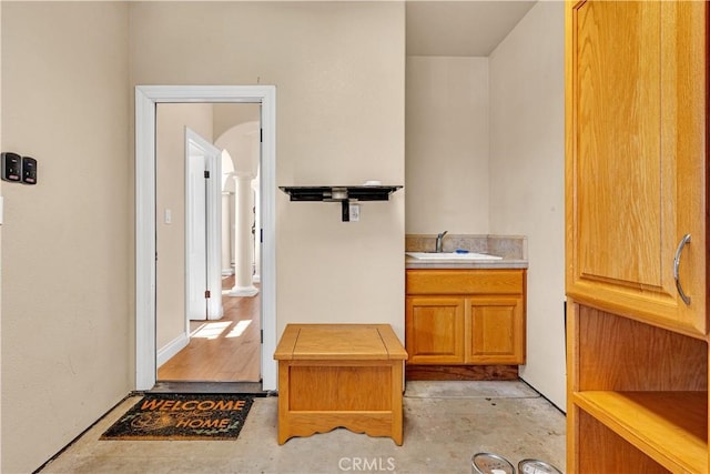 bathroom featuring vanity, concrete floors, and ornate columns