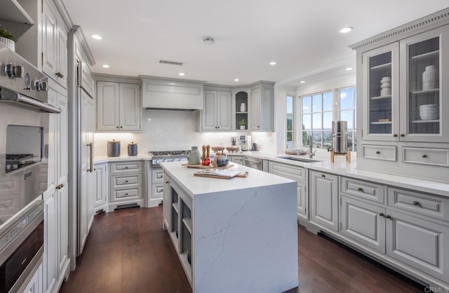 kitchen with stainless steel appliances, gray cabinets, sink, and a kitchen island