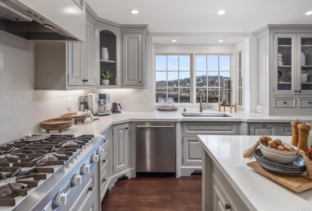 kitchen with range hood, dishwasher, sink, gray cabinetry, and cooktop