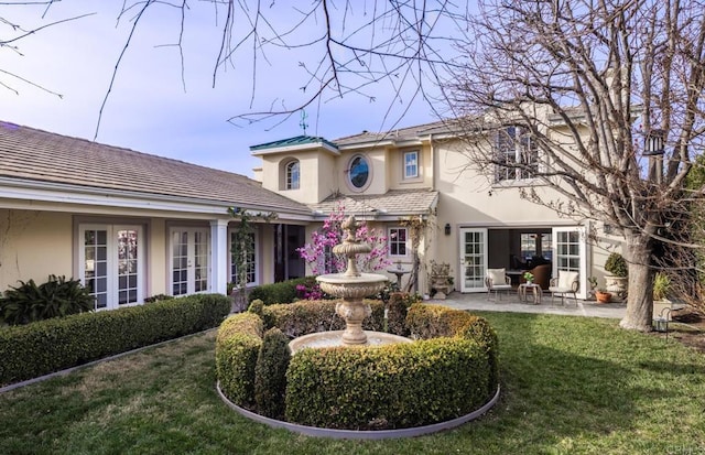 back of house with a yard and a patio