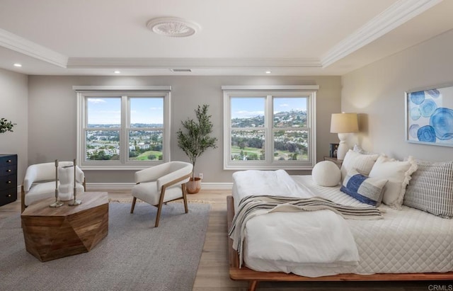 bedroom with crown molding, a tray ceiling, and multiple windows