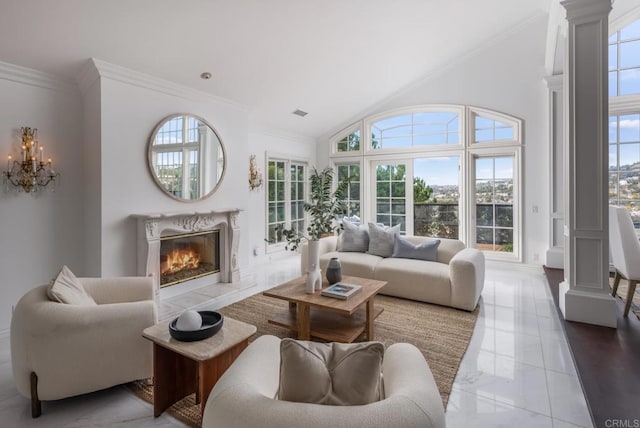 living room with decorative columns, a wealth of natural light, and a high end fireplace