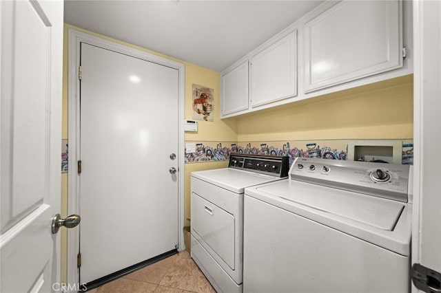 washroom with separate washer and dryer, light tile patterned floors, and cabinets