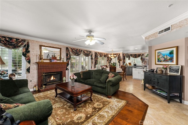 tiled living room with a brick fireplace, ornamental molding, and ceiling fan