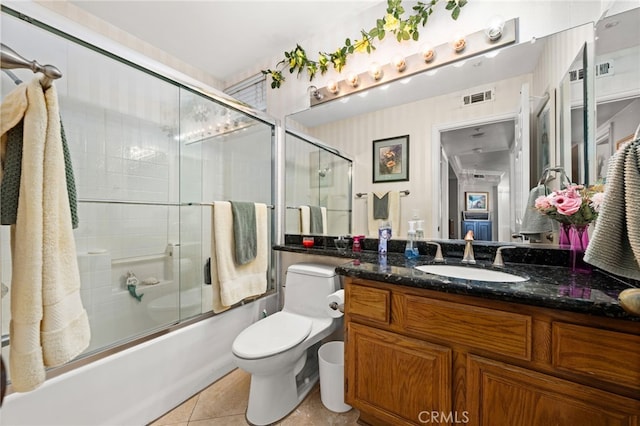 full bathroom featuring tile patterned flooring, vanity, combined bath / shower with glass door, and toilet